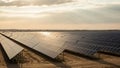 Vast solar panel array stretching across a flat landscape under a partly cloudy sky with sun rays breaking through the clouds at Royalty Free Stock Photo