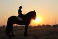 Landscape silhouette photo of a horseman on a horse with sunset. Royalty Free Stock Photo