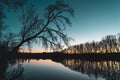 Landscape of silhouettes of trees and reflection in the river at sunset. Contrast cold and warm colors in autumn. Romantic sunset Royalty Free Stock Photo