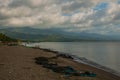 Landscape sky with clouds, volcanic sand on the beach. Pandan, Panay, Philippines. Royalty Free Stock Photo