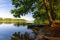 Landscape with a small boat moored by a large leafy tree Royalty Free Stock Photo