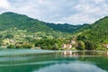 The landscape of a small town on the slopes of picturesque mountains descending to the shore of the azure lake.