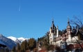 Landscape with snow-capped mountains, Peles palace, blue sky and