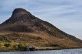 Landscape of steep hill peak with small boathouse on lake in for