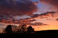 landscape with stunning sunset in the fields with some tree silhouet in the back Royalty Free Stock Photo