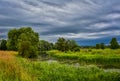 Landscape. Summer day, cloudy sky, river in the grass