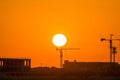 Landscape of sun rising over the construction site with crane in the sea in the morning in Dammam, Kingdom of Saudi Arabia Royalty Free Stock Photo