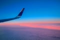 Landscape sunrise over the clouds seen from the window of a flying passenger airliner. View of the wing aircraft. Air travel.