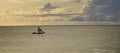 Sunrise over the Indian Ocean. Sailboat under yellow, cloudy sky