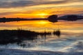 Landscape at sunset with reflection of the sky over the water of a lake Royalty Free Stock Photo