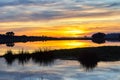 Landscape at sunset with reflection of the sky over the water of a lake Royalty Free Stock Photo