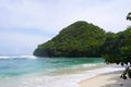 Landscape of the Teluk Asmara Beach surrounded by hills and greenery in Indonesia