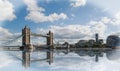 Landscape of Tower Bridge in London, with a nice water reflection and blue cloudy sky Royalty Free Stock Photo