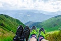 Landscape, travel, tourism. A pair of feet in the shoes against the background of the mountains. Horizontal frame Royalty Free Stock Photo