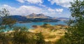 Landscape of turquoise lake with mountains and hills in andalusia with road meadows and bushes