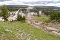 Landscape at the Upper Geyser Basin in Yellowstone National Park where steam rises from geyser vents and hot springs near a forest Royalty Free Stock Photo