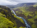 Landscape valley of river Fossa with blue water stream and green hills and moss covered cliffs, in South Iceland, summer