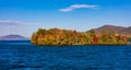 Landscape view of  autumn trees in the middle of Lake George coast under a blue sky Royalty Free Stock Photo