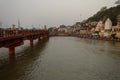 A landscape view of bridge at ganga river in haridwar public going to take bath in ganga river temple sky