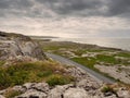 Landscape view in Burren National park, Atlantic ocean, Small road, rough terrain, dramatic sky, Part of Wild Atlantic Way