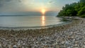 Landscape view of colorful sunset on a pebble beach Royalty Free Stock Photo