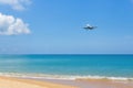 Landscape view contained with blue sky and sea, golden sand while air plane landing on runway near the coast Royalty Free Stock Photo