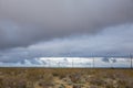 Landscape view of deserted land with a heavily clouded sky and utility poles