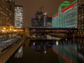 Landscape view of elevated `el` train crosses a still Chicago River with Christmas/holiday lights Royalty Free Stock Photo