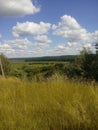 Landscape view of green grass on slope with blue sky and clouds background Royalty Free Stock Photo