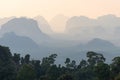 Landscape of silhouettes tropical hazy mountains perspective and the green jungle trees in the foreground Royalty Free Stock Photo