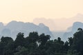 View from the height of silhouettes tropical hazy mountains perspective and the green jungle trees in the foreground Royalty Free Stock Photo