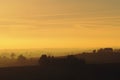 Landscape view of the hills during sunset on a foggy day Royalty Free Stock Photo