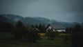 Landscape view of the house in the forest with lush trees in the background on a foggy day Royalty Free Stock Photo