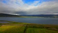 Landscape view of Hvalfjorour (Whale Fjord) hulking mountains, lush vegetation by the sea in Iceland