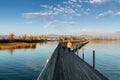 Landscape view of marsh and lake shore with the town of Rapperswil in evening light and a long wooden boardwalk in the foreground