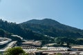 Landscape view of mountain with greenhouse roof under sunny day. Greenhouse in farmland. Sunray with greenhouse and mountain Royalty Free Stock Photo