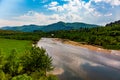 Landscape view of the mountain river with green vegetation trees bushes and grass and blue sky in summer Royalty Free Stock Photo