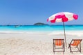 Beautiful ocean blue sky and boat with  Pink umbrellas with Empty chairs on a sandy sea Royalty Free Stock Photo