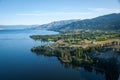 Landscape view of Okanagan Lake with vineyards ad orchards near the beach Royalty Free Stock Photo