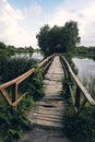 Landscape view of Old small wooden bridge across the lake. Fishman house on an island surrounded by wather and forest Royalty Free Stock Photo