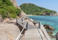 Landscape view of old wooden walkway bridge through the rock at Koh Nang Yuan Island under blue sky in summer day