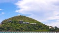 Landscape view of resort or village with solar cell rooftop on green mountain and blue sky with clouds background