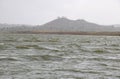 Landscape view of river bank with dry land and hill Royalty Free Stock Photo