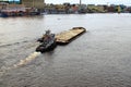 Landscape view of the river barge loaded with sand and two tugboats. Embankment of Dnipro River