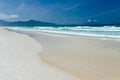 Landscape view of the sandy sea beach. Calm waves, foam. Blue sky with white clouds. Summer vacation, travel. Background, copy Royalty Free Stock Photo