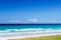 Landscape view of the sandy sea beach. Calm waves, foam. Blue sky with white clouds. Summer vacation, travel. Background, copy Royalty Free Stock Photo