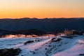 Landscape view with snowy and rocky mountain at sunset, fiery sky and sun background