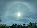 Landscape view of stunning sun halo over tree-lined landscape.