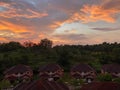 A landscape view of sunset, hills forest and houses