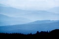 Landscape view from top of mountain on misty morning across countryside with fading layers